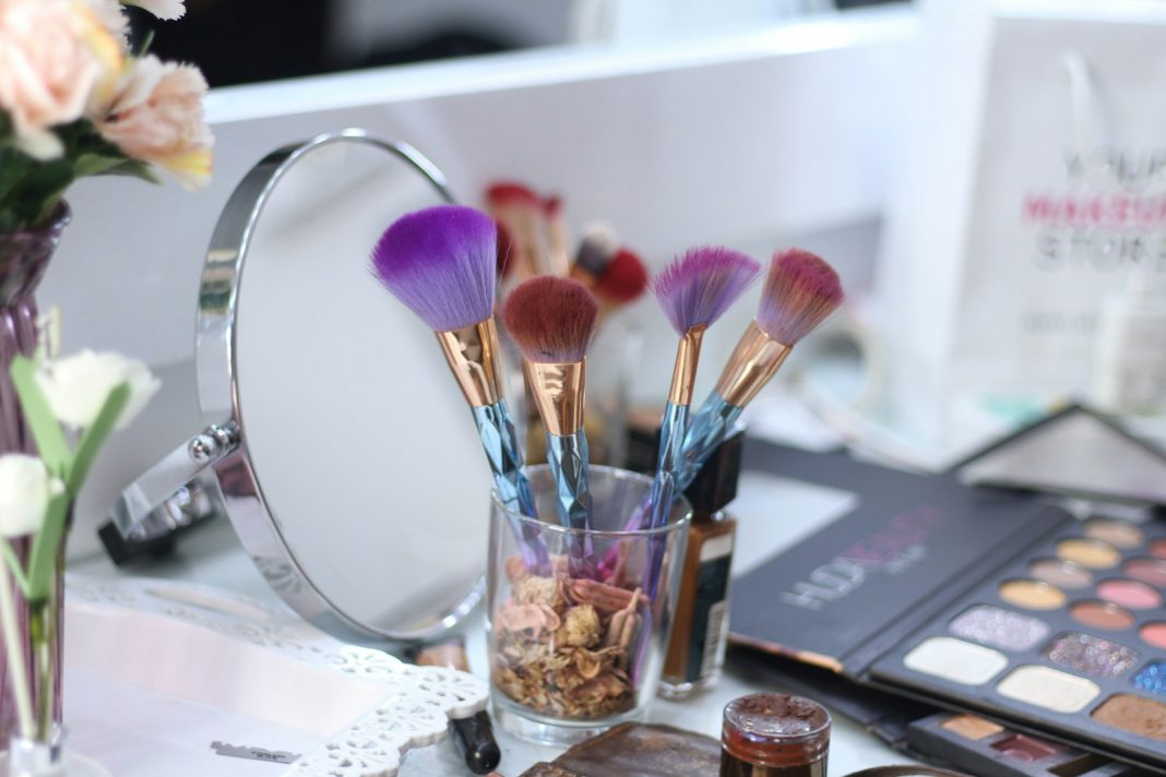 a close up of makeup brushes in a cup on a table