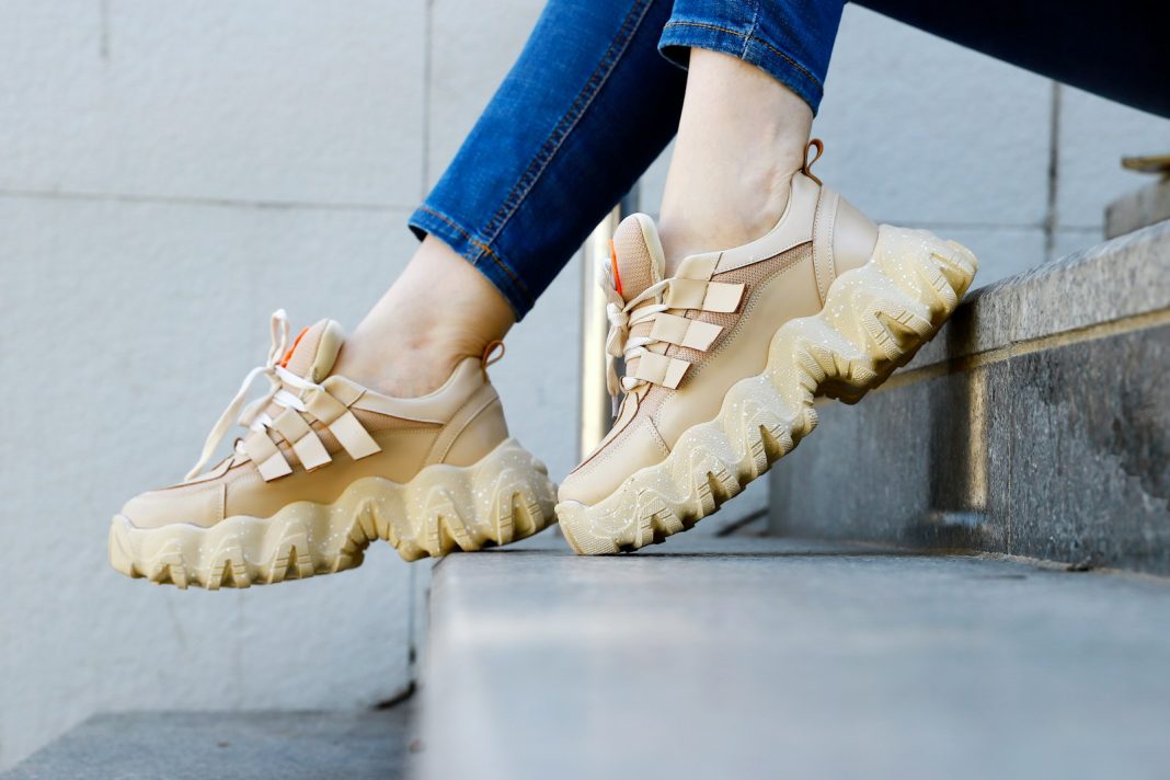 a person's feet wearing brown shoes