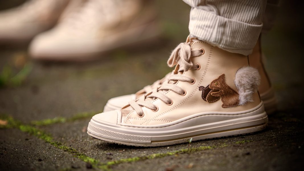 Cream-colored sneakers with adorable, furry embellishments.
