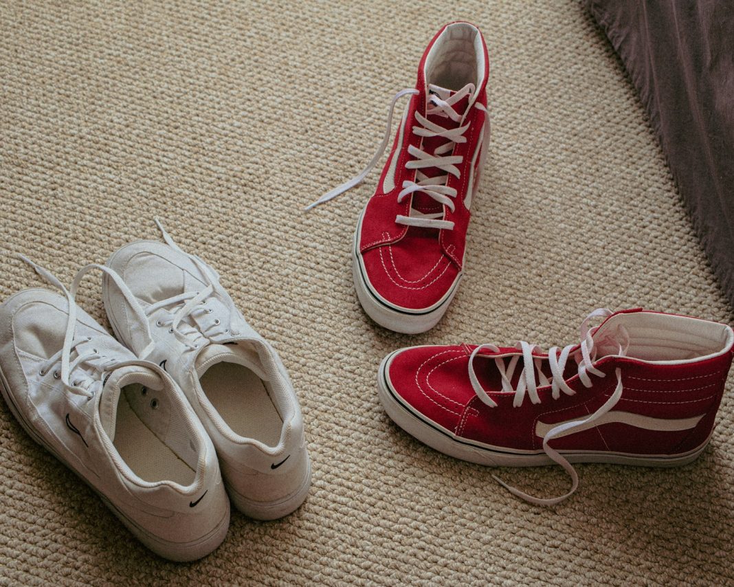 a pair of red and white tennis shoes on the floor